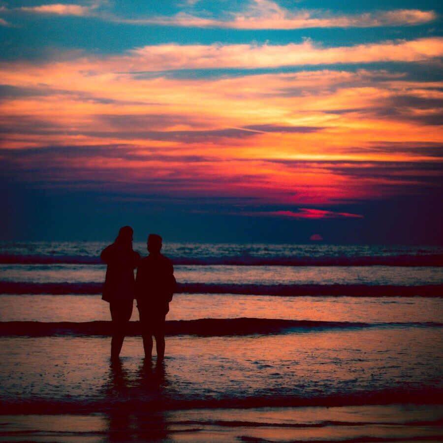 夕阳下海边并行的两个剪影